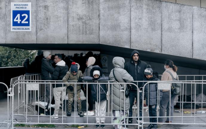 mensen op de vlucht staan in de wachtrij aan aanmeldcentrum voor asielzoekers Pacheco